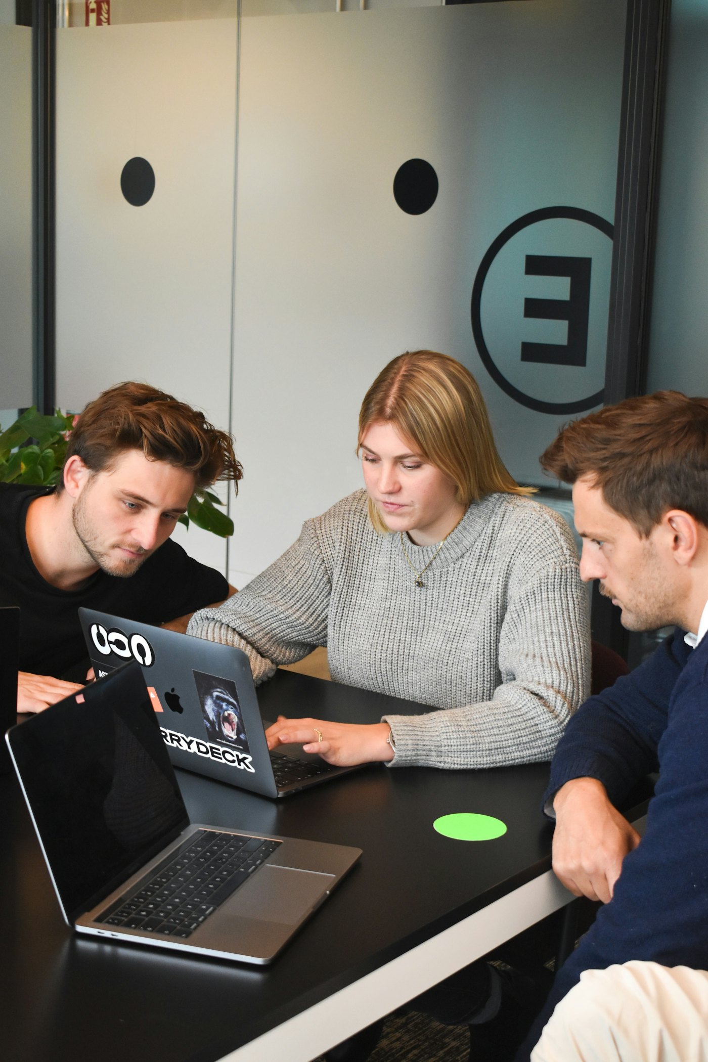 Three colleagues collaborating on a laptop